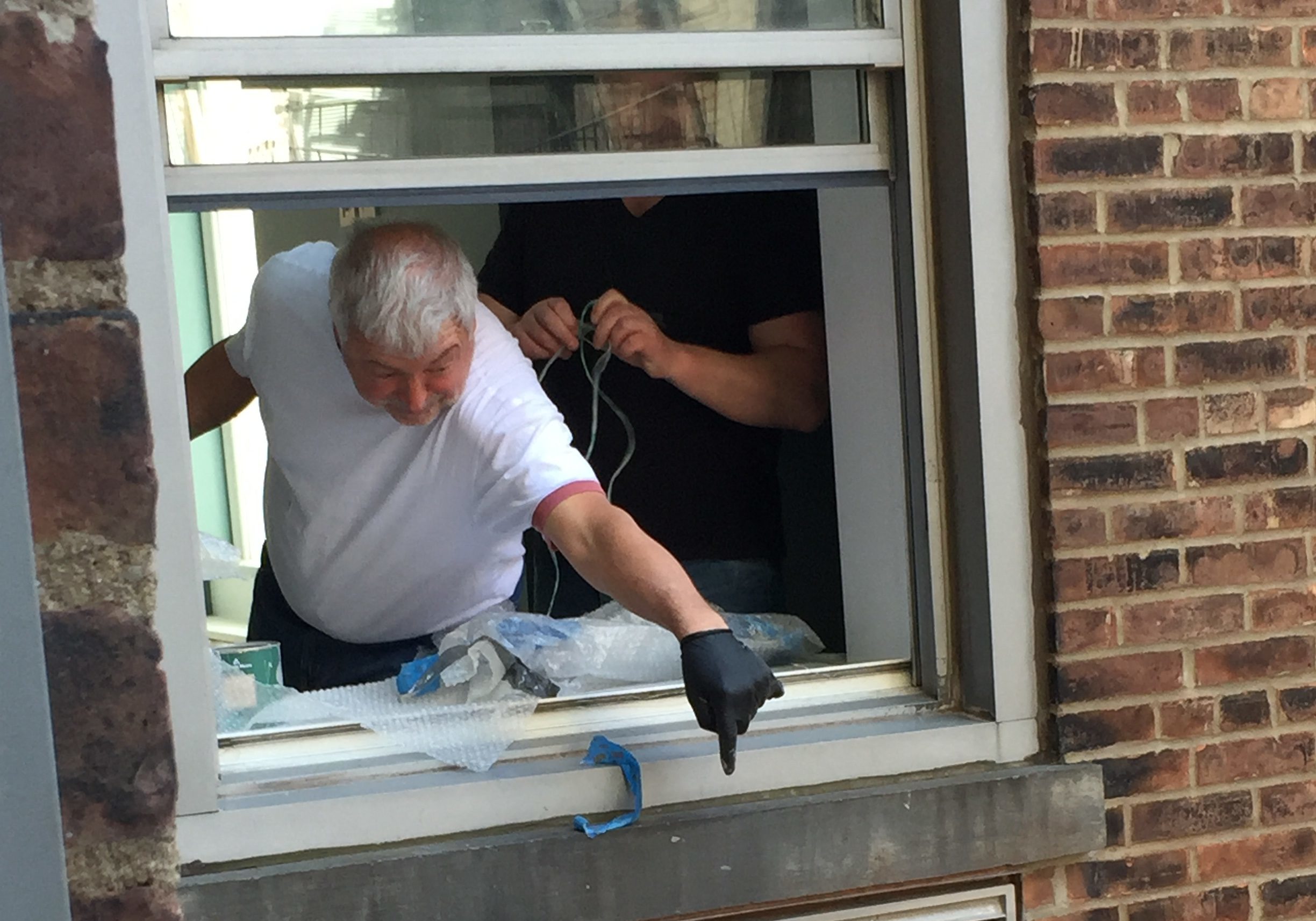 A man is working on the window of his home.